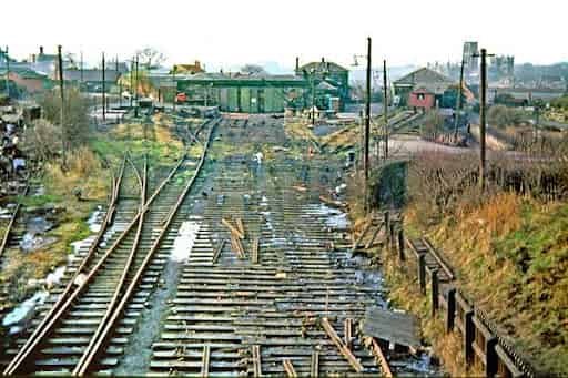 A Historical image of Gilesgate railway station. The view shows two curved tracks leading past a stone station house, a wooden signal box, and several rail sidings.